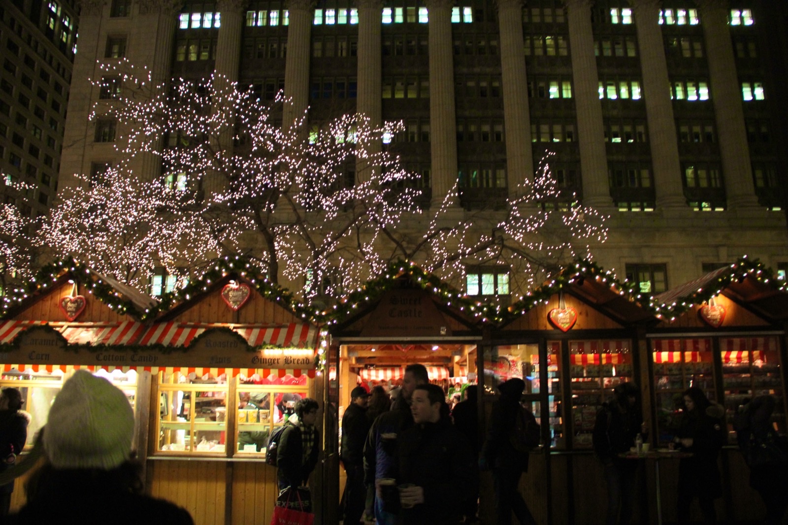 夜のイルミネーションに照らされるクリスマスマーケットの屋台